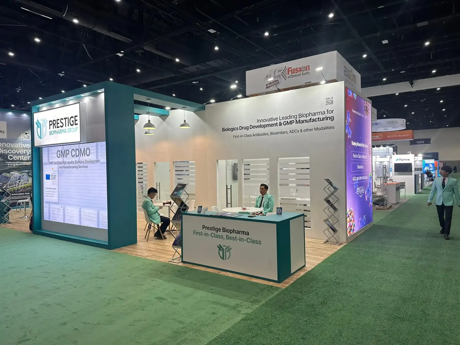 Exhibition booth with company representatives seated.