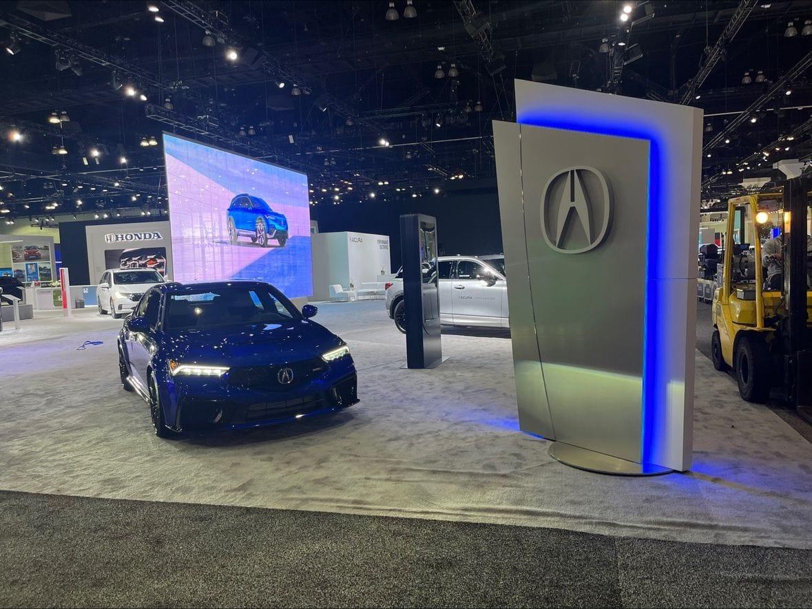 Acura exhibit with cars and illuminated logo
